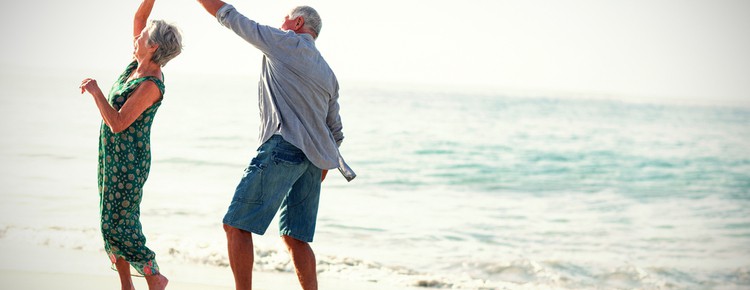 Retired couple dancing on a beach