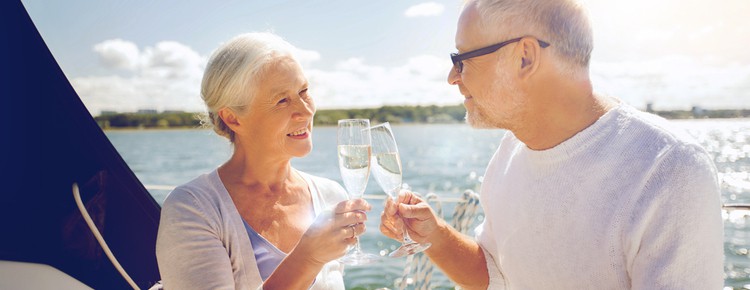 Senior couple clinking champagne on a yacht deck