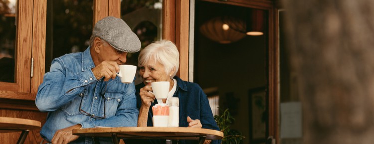A senior couple enjoying a coffee outside of a cafe