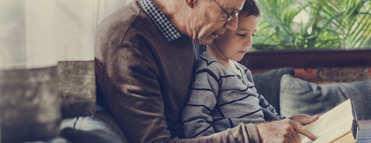 A grandfather and grandson reading a book together