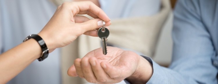 A couple receiving keys from an estate agent.