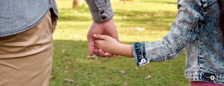 Parent and child holding hands.