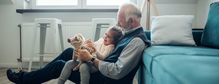 A grandfather playing with his granddaughter.