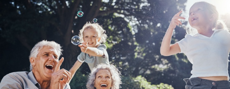 Grandparents blowing bubbles with their grandchildren.