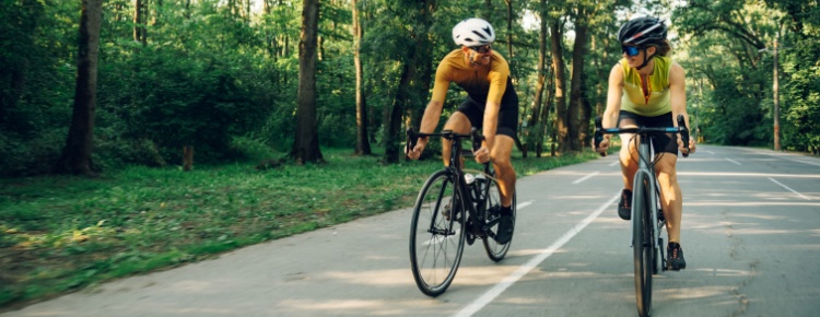 A couple cycling together on a road.