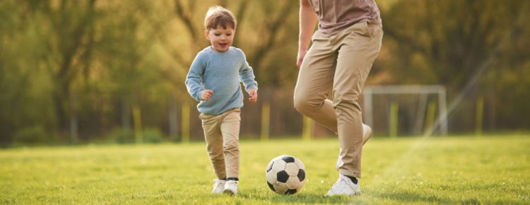 A father playing football with his young son.