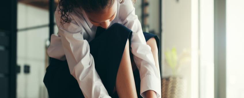 A girl putting on school shoes.