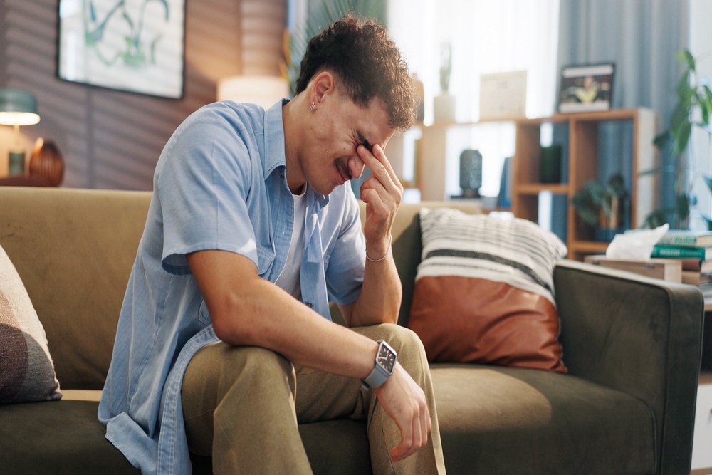 A stressed man with his head in his hand.
