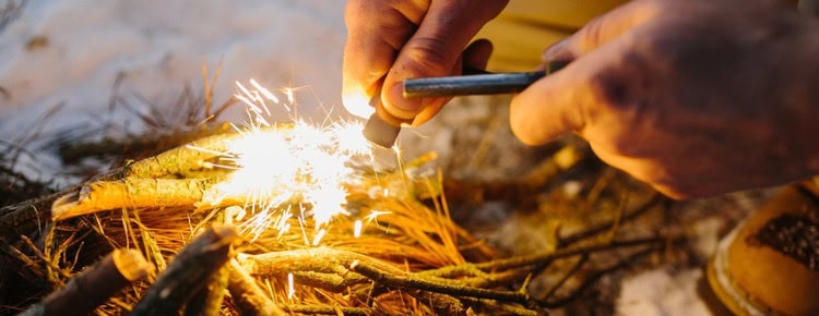 A close-up of a man starting a fire.
