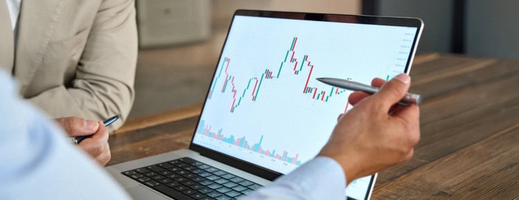 A man reviewing stock market movements on a laptop.